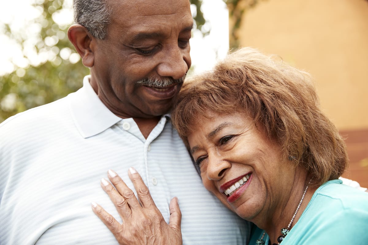 elderly couple hugging after good home health aide service